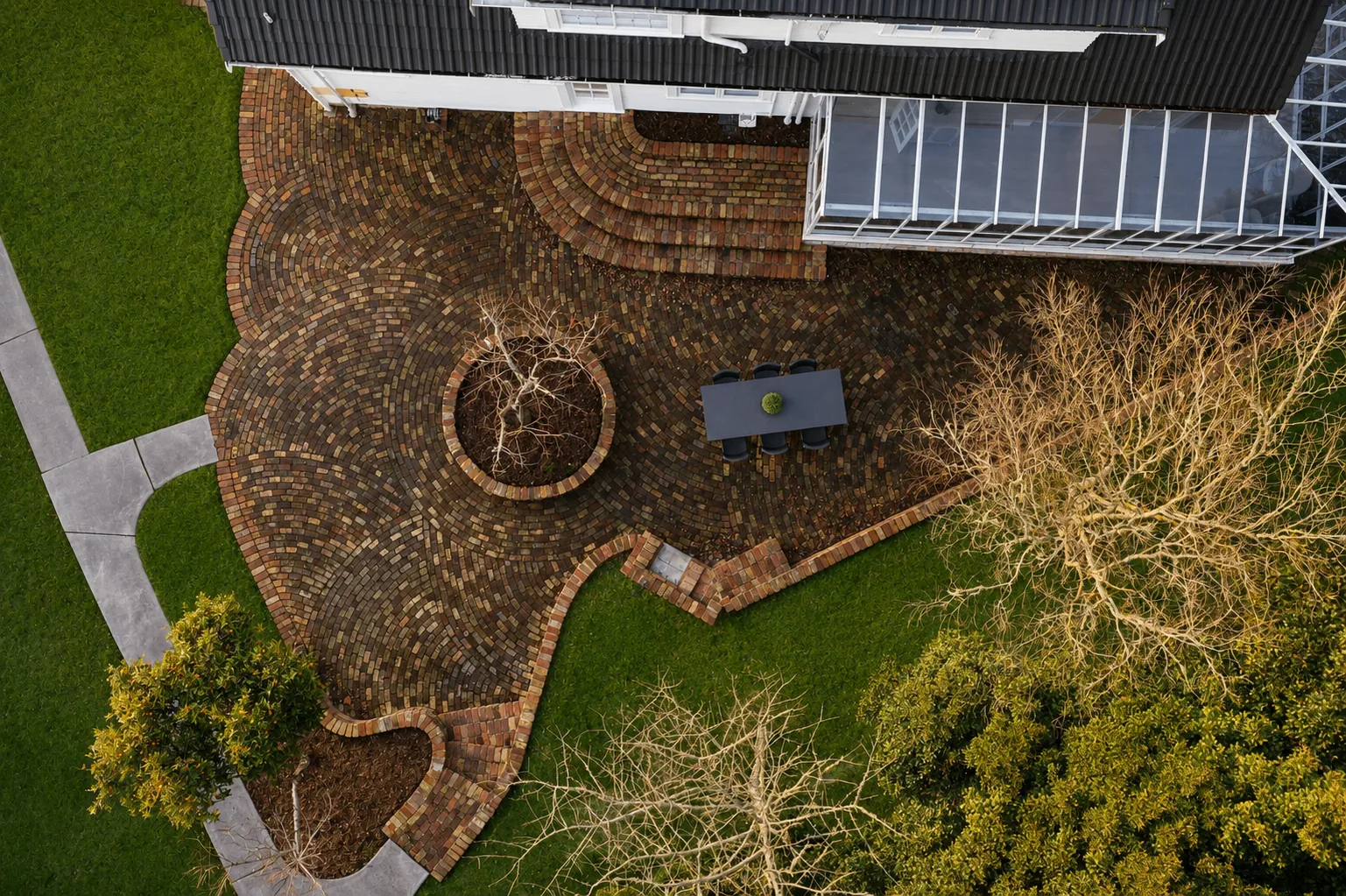 Aerial view of curved brick courtyard with dining setting