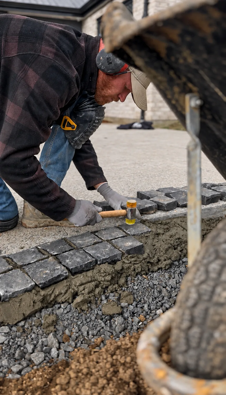 Landscape tradesman setting cobblestones by hand during construction at Coatesville Riverhead Highway