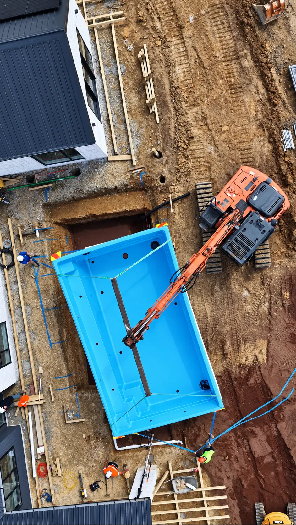 Aerial view of the excavator lowering the pool shell into its excavation at Coatesville Riverhead Highway
